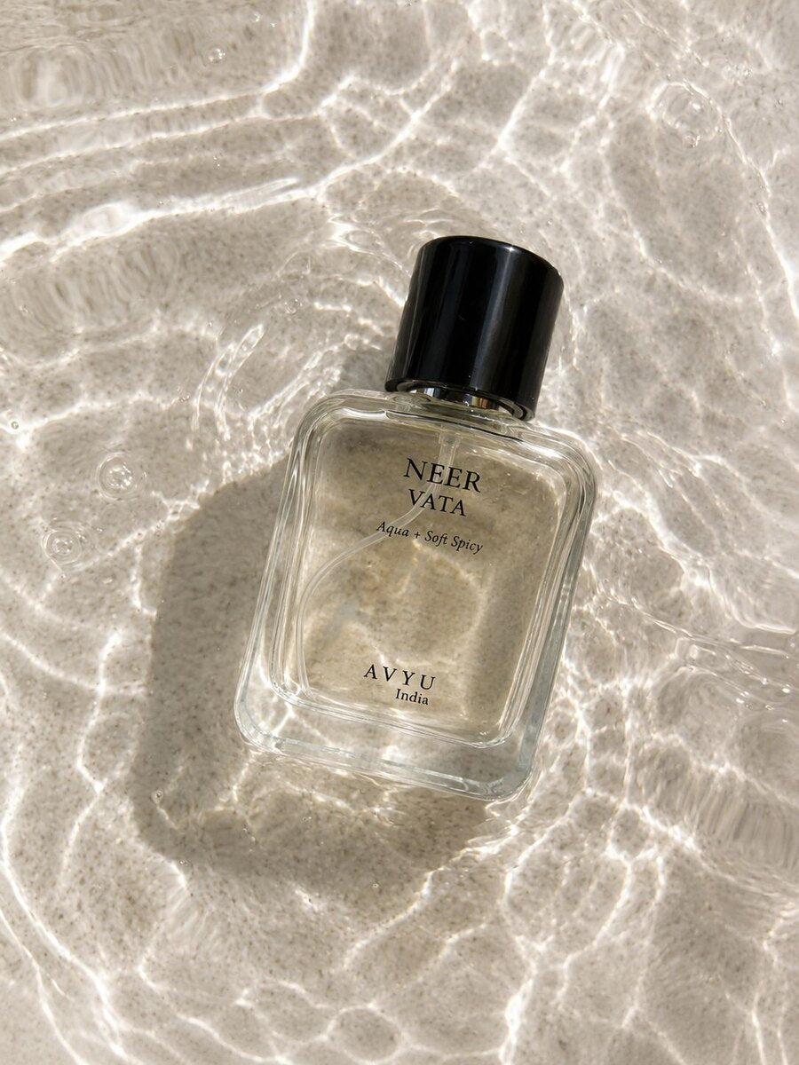 Neer Vata perfume surrounded by clear water and reflected light